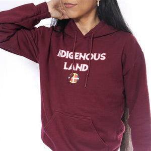 Person wearing a maroon hoodie with 'Indigenous Land' text on a white background